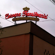 Firma exterioara cu litere de tabla galvanizata si vopsita, avand tub de neon modelat pe centrul literelor.